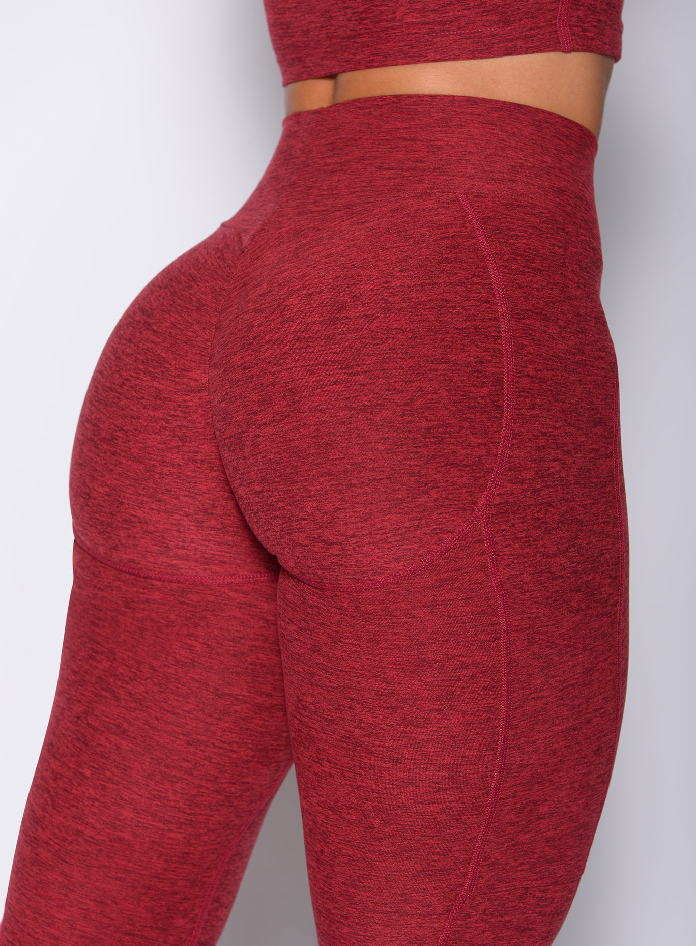 Zoomed in back profile view of our uplift pocket leggings in red rose color 