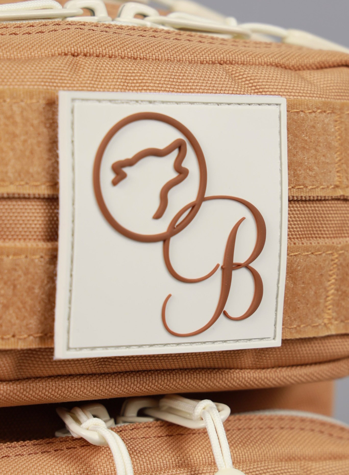 A close up picture of the Bombshell Sportswear X WOLFpak collaboration logo on the 9L Backpack Mini Bombshell Sportswear in Caramel color