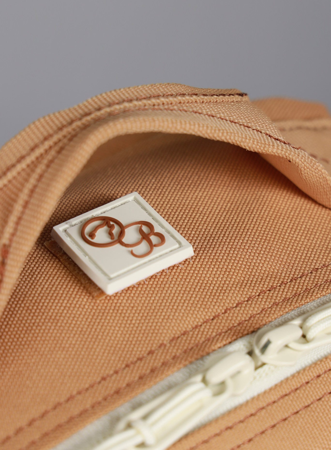 top side view of the Bombshell Sportswear X WOLFpak logo on the 9L Backpack Mini Bombshell Sportswear in Caramel color