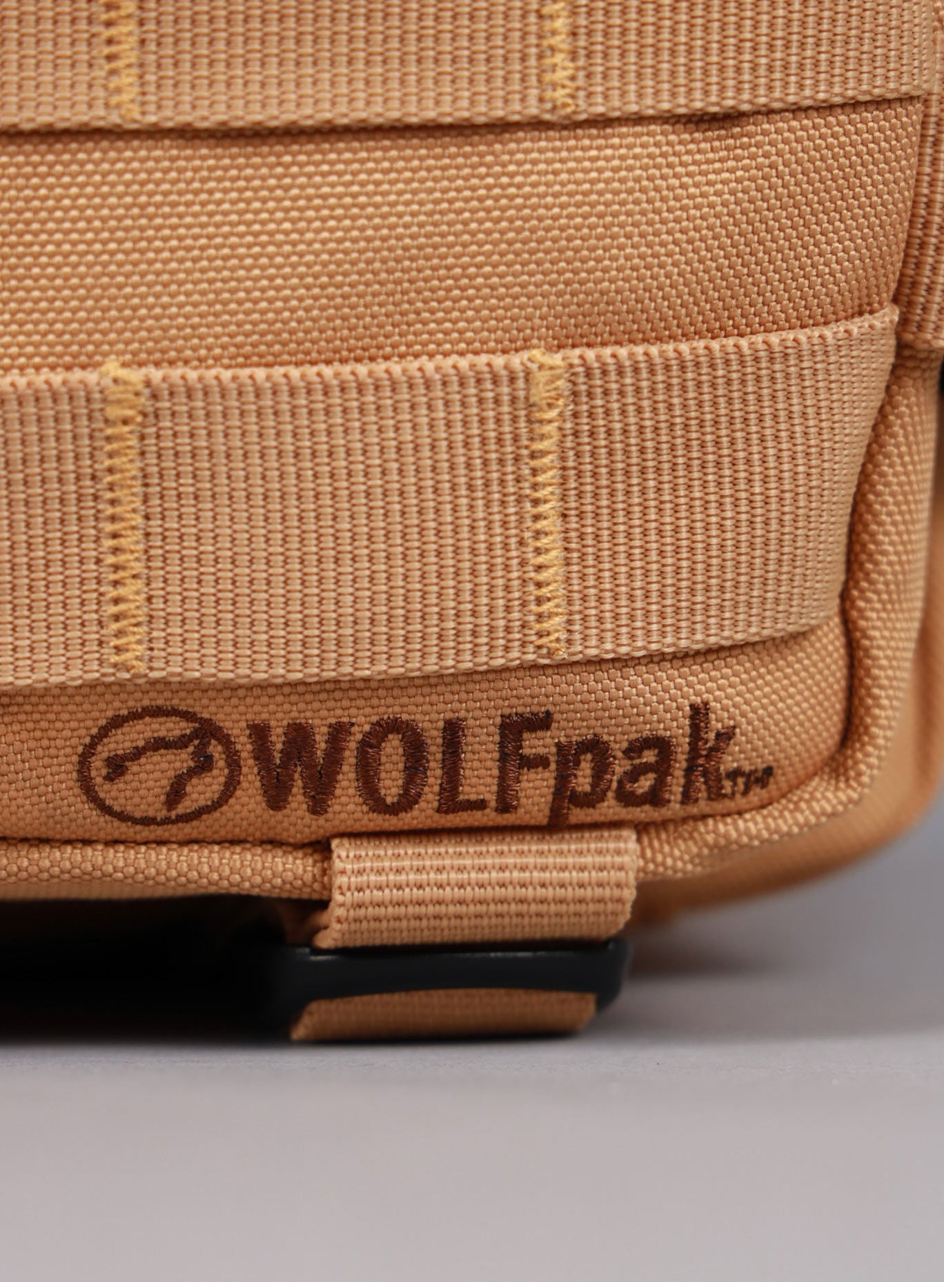 close up shot of the WOLFpak logo on the 9L Backpack Mini Bombshell Sportswear in Caramel color