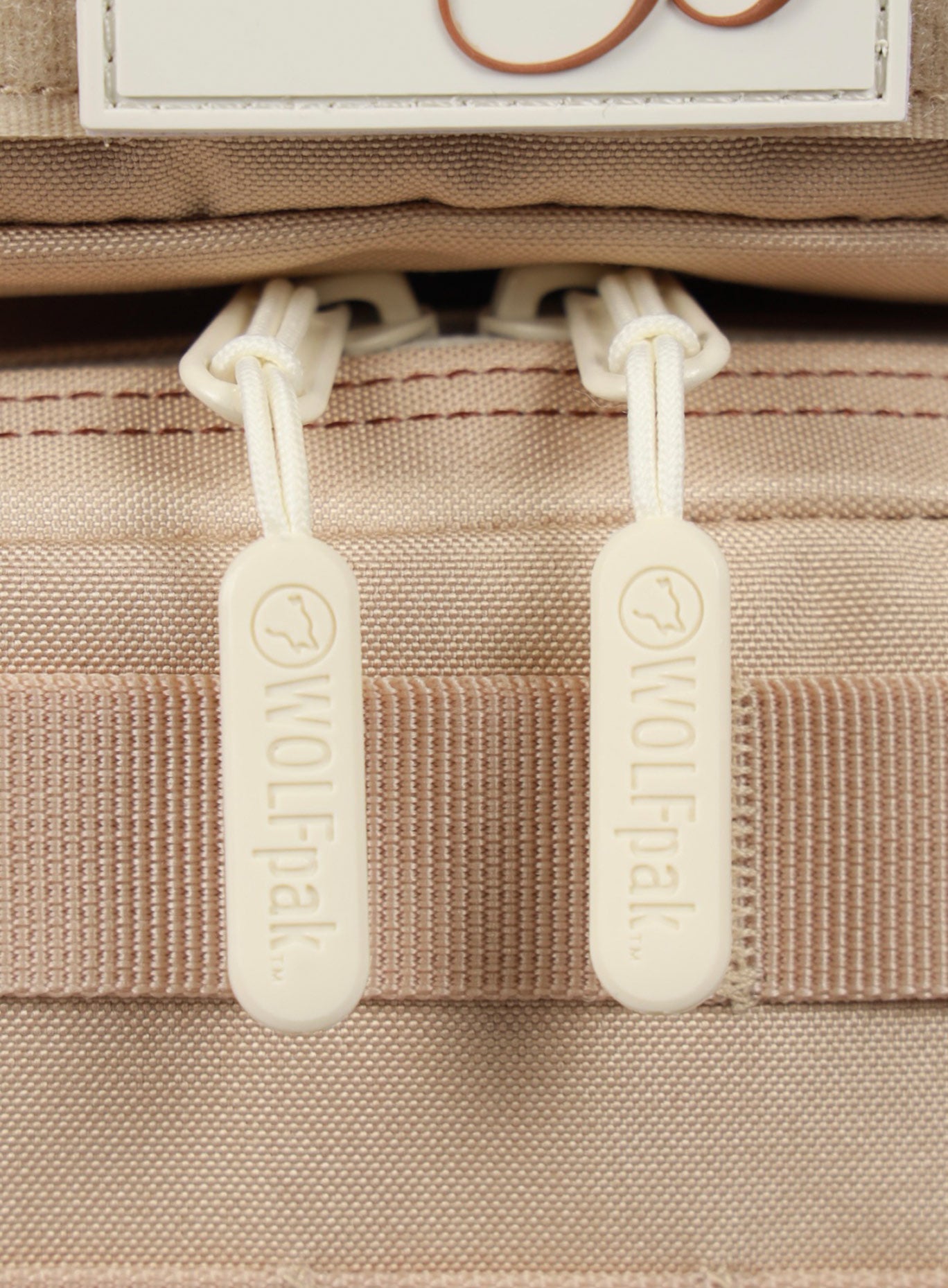 A close up picture of the zipper pull on the 9L Mini Bombshell Sportswear Latte backpack