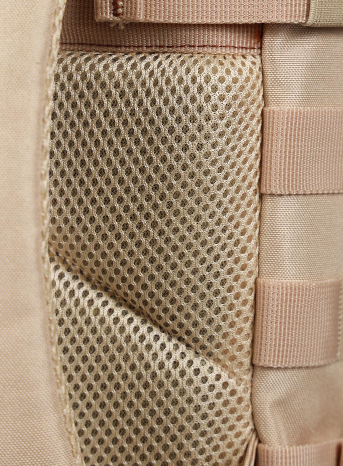 A close up picture showing the back padding on the 9L Mini Bombshell Sportswear Latte backpack