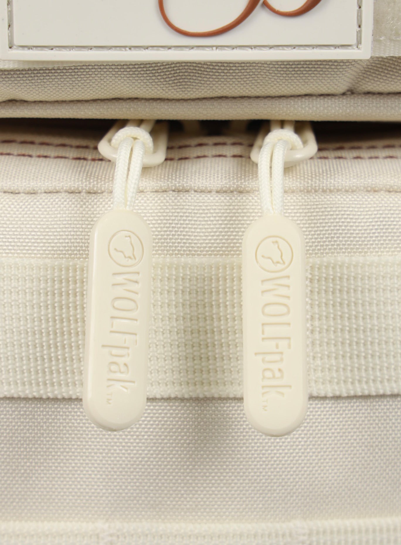 close up picture of the  zipper pull on the 9L Backpack Mini Bombshell Sportswear in Crème color