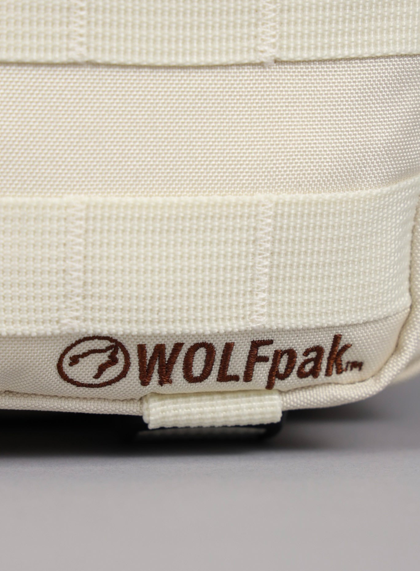 close up shot of the WOLFpak logo on the 9L Backpack Mini Bombshell Sportswear in Crème color