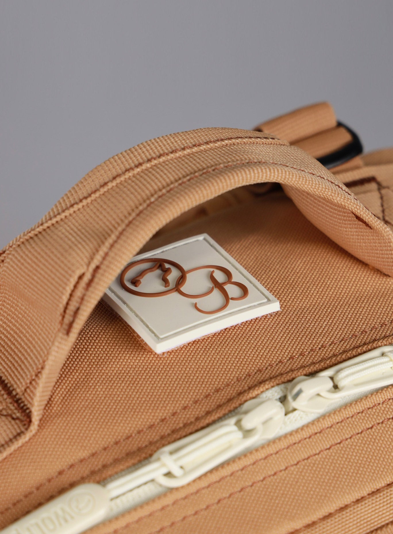 top side view of the Bombshell Sportswear X WOLFpak logo on the   25L Backpack Bombshell Sportswear in Caramel color