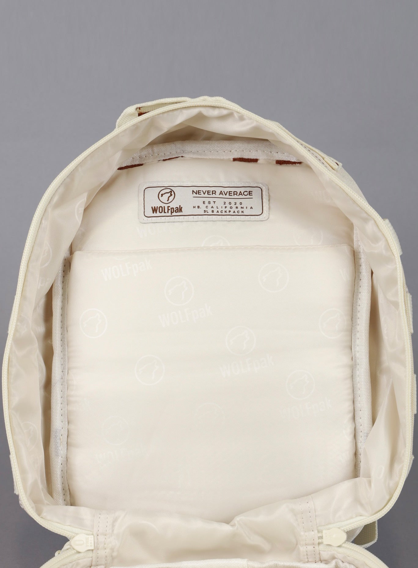 A picture showing the main compartment on the 9L Backpack Mini Bombshell Sportswear in Crème color unzipped