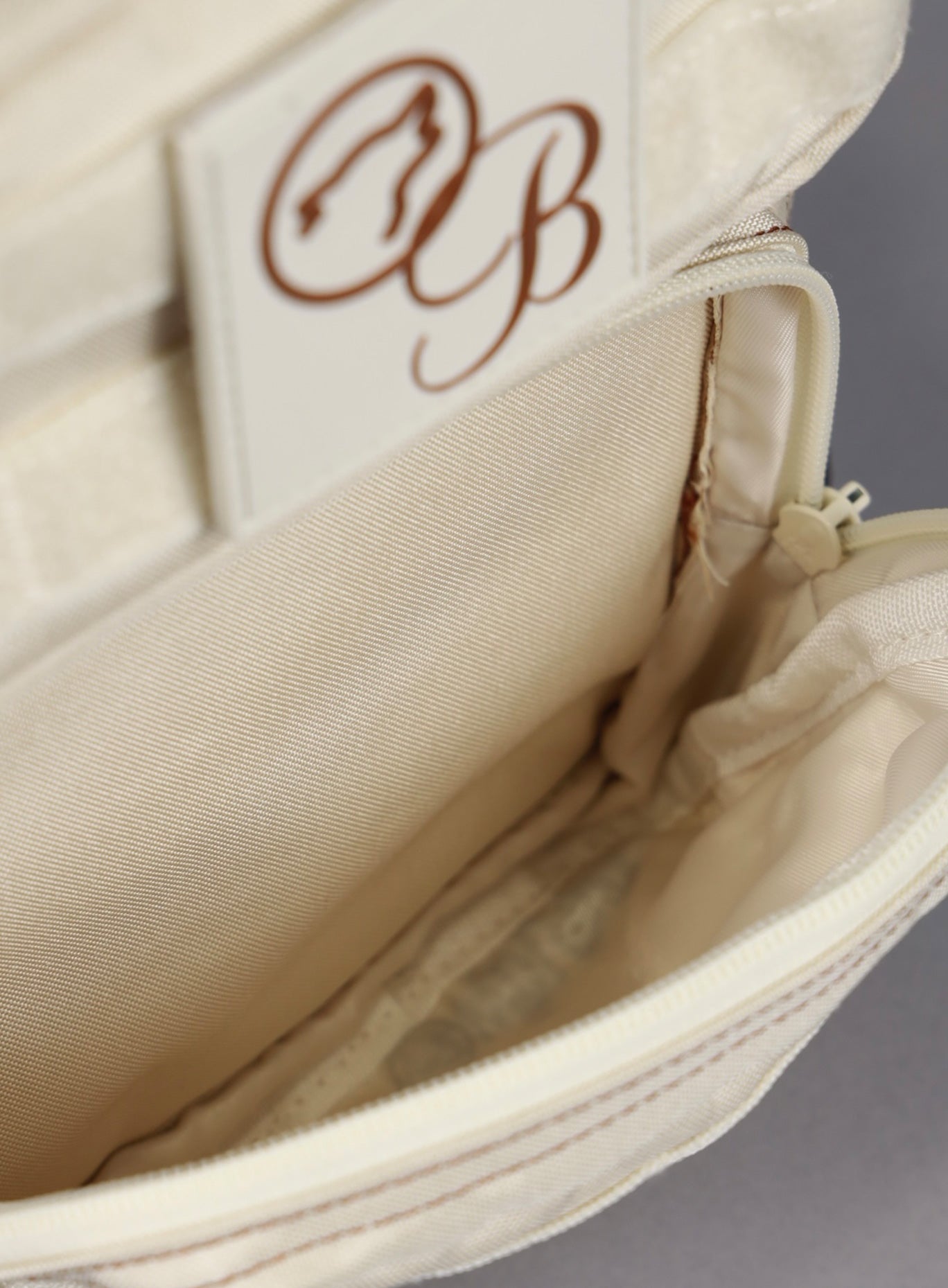 A picture showing the outermost compartment on the the 9L Backpack Mini Bombshell Sportswear in Crème color