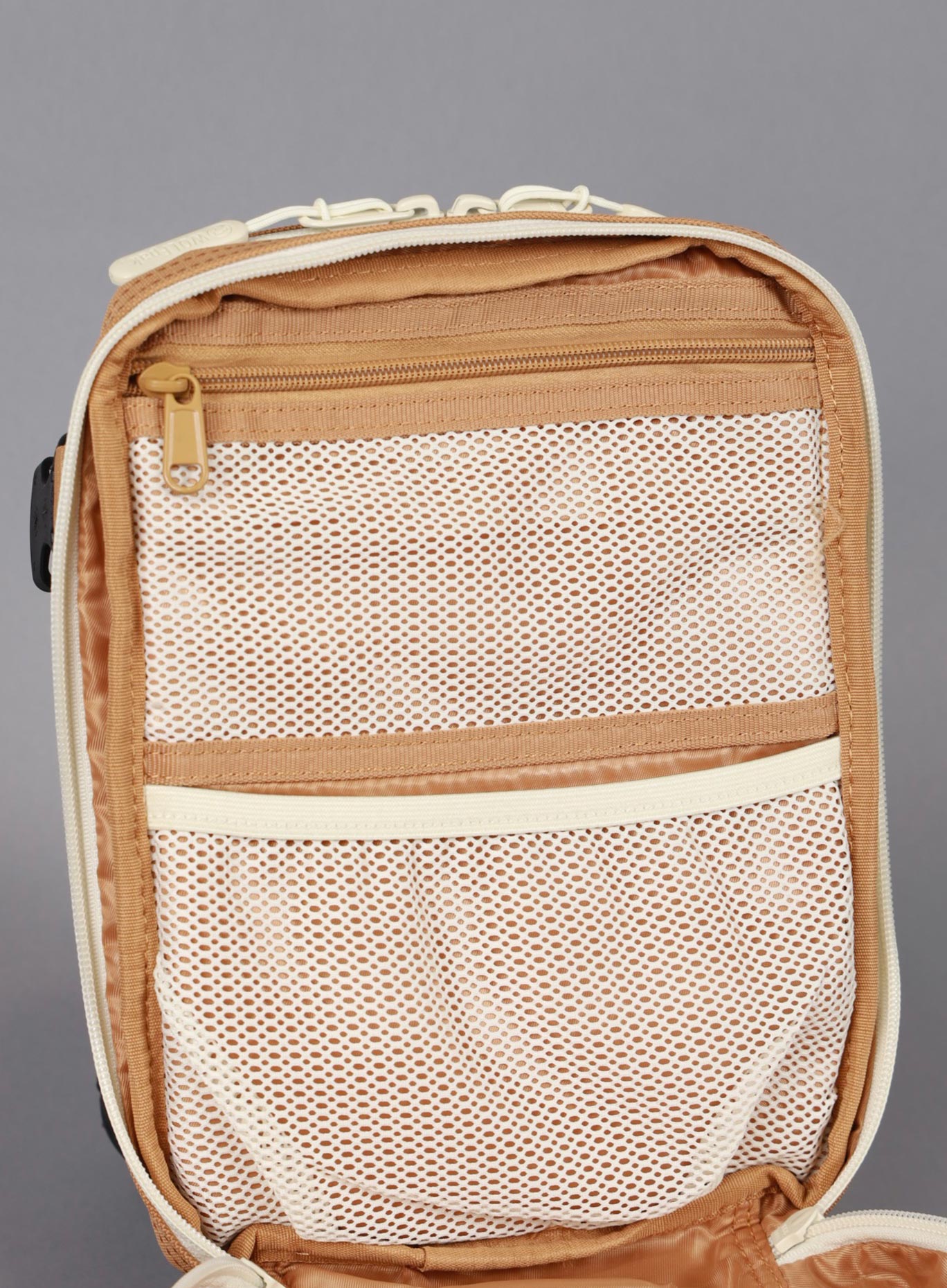 A unzipped picture of the the 9L Backpack Mini Bombshell Sportswear in Caramel color showing the mesh compartments