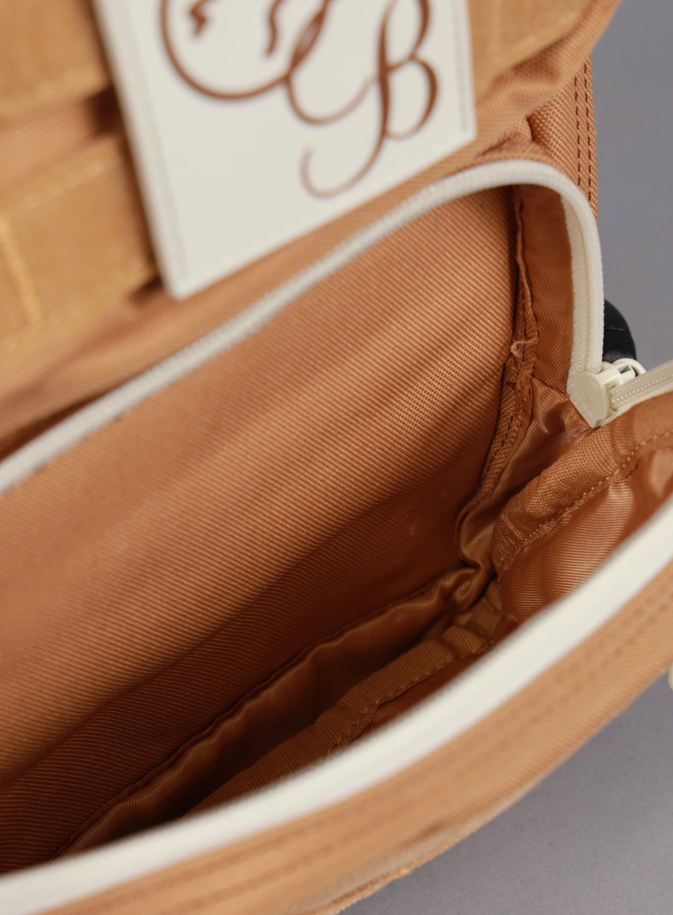 A picture showing the outermost compartment on the the 9L Backpack Mini Bombshell Sportswear in Caramel color