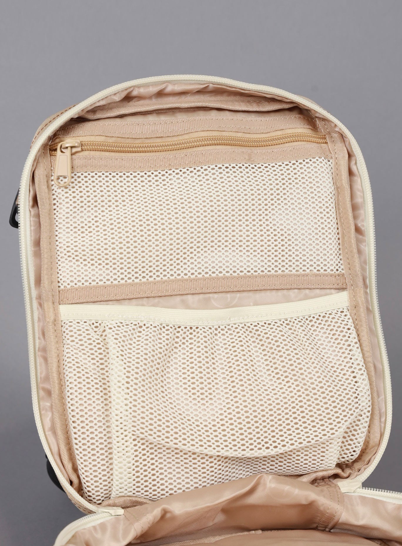 The image showing the inside of the 9L Mini Bombshell Sportswear Latte backpack with mesh compartments. 