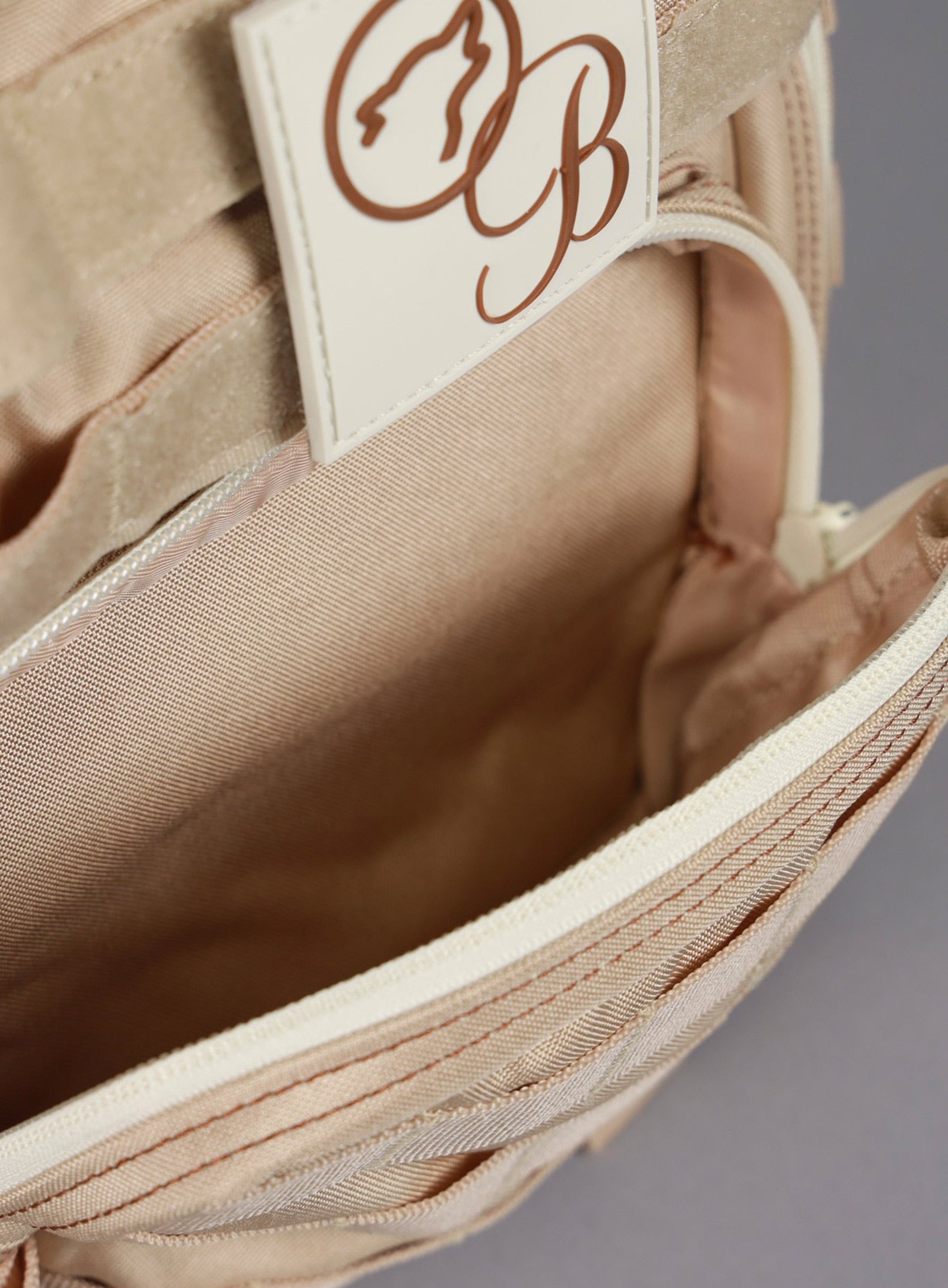 An image featuring the top compartment of the 9L Mini Bombshell Sportswear Latte backpack opened 