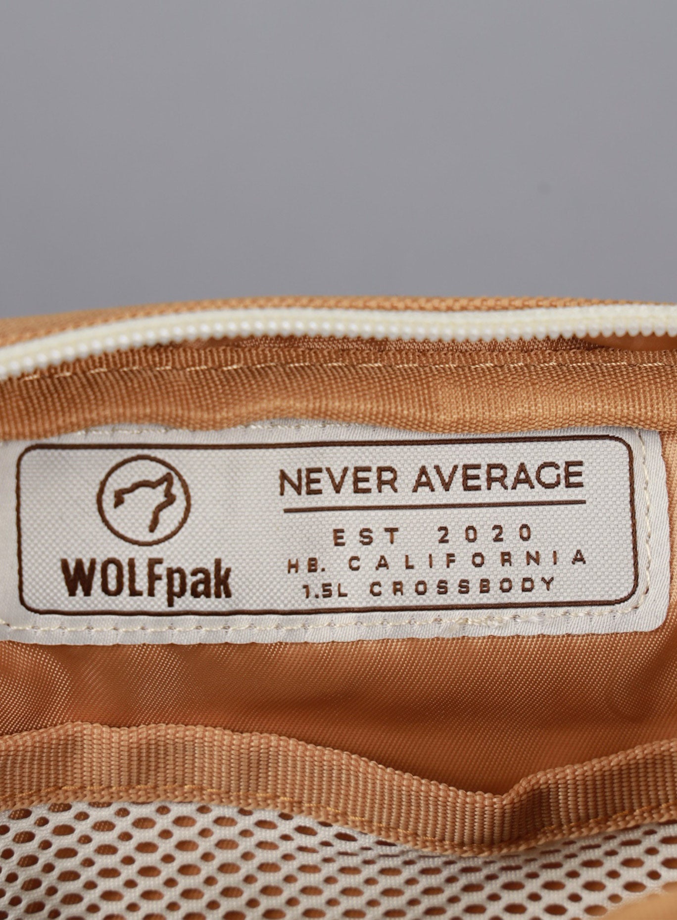 A picture showing the WOLFpak label inside the 1.5L Crossbody Pack Bombshell Sportswear in  Caramel color