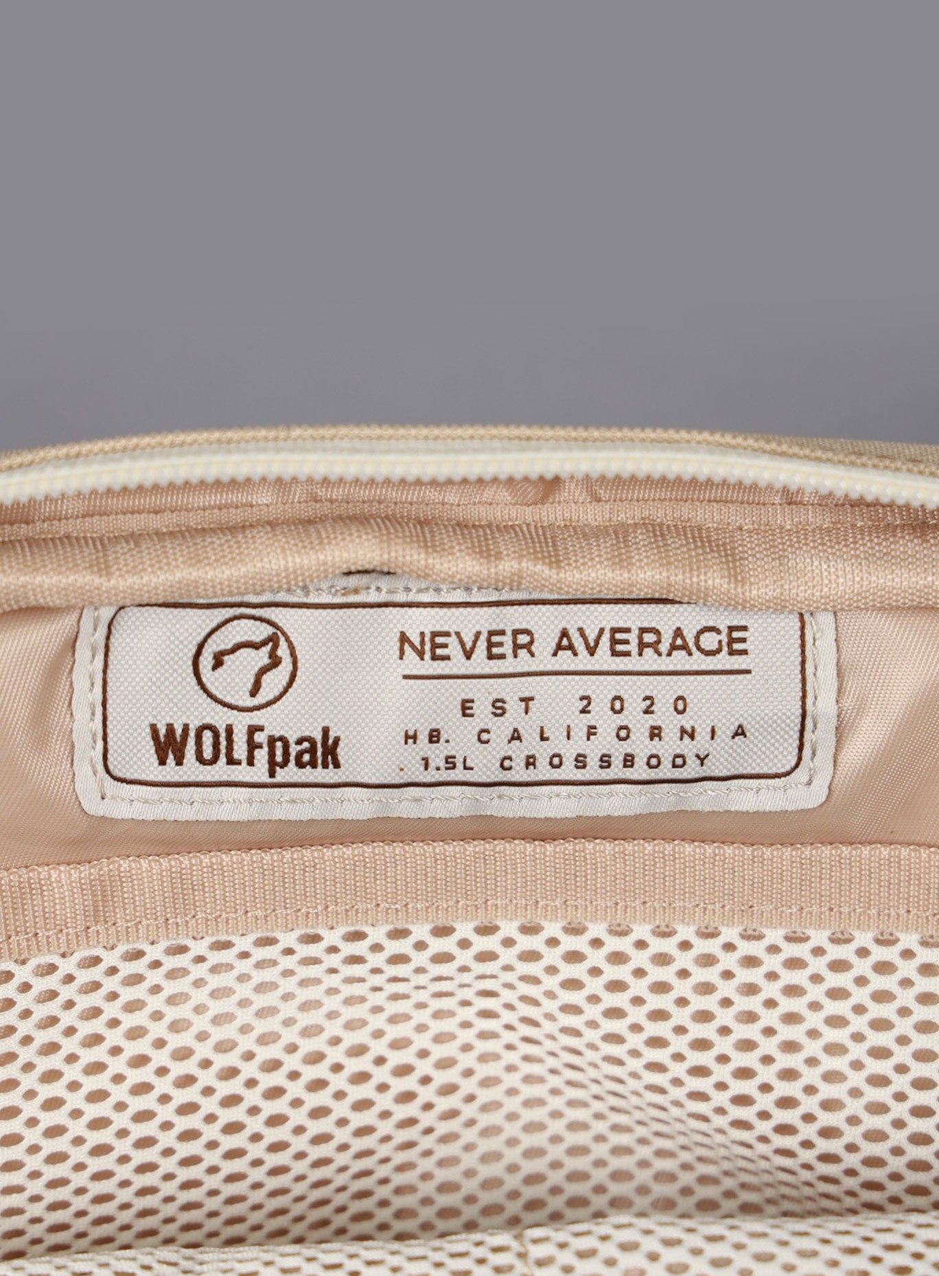 A picture showing the WOLFpak label inside the 1.5L Crossbody Pack Bombshell Sportswear in  Latte color
