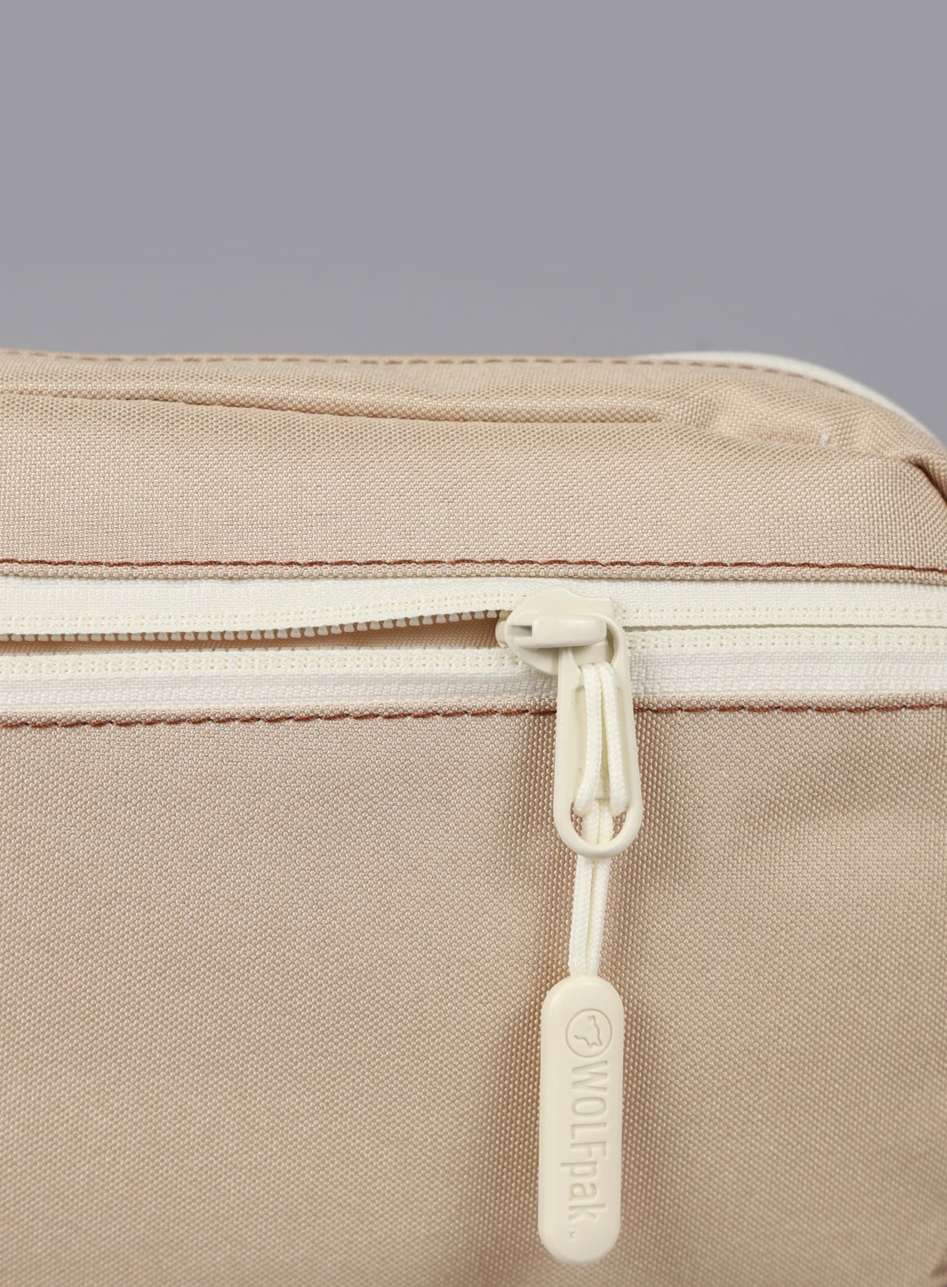 A picture showing the zipper on the 1.5L Crossbody Pack Bombshell Sportswear in  Latte color