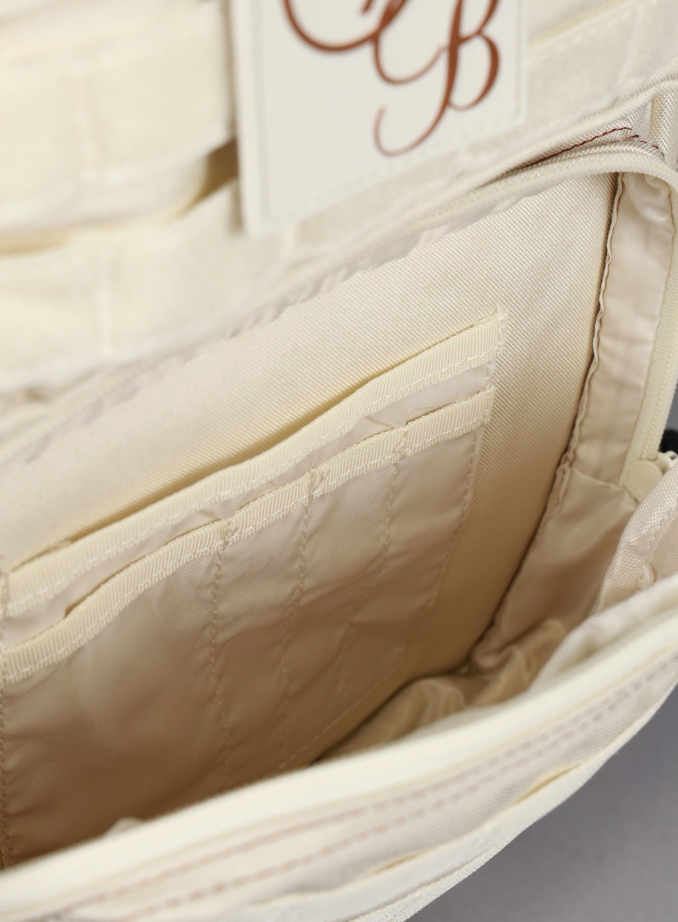 A picture showing the outermost compartment at the bottom on the   25L Backpack Bombshell Sportswear in Crème color