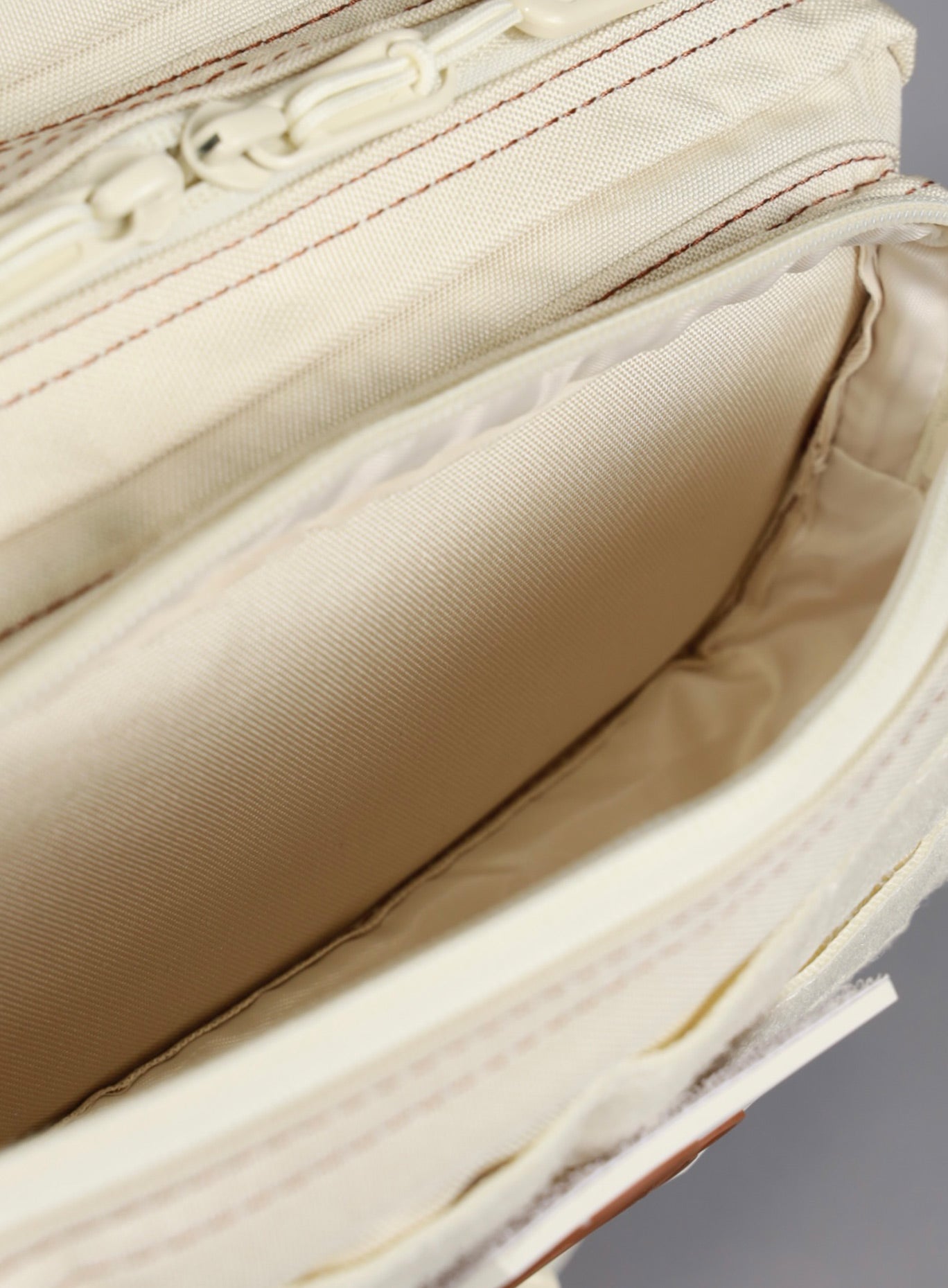 A picture showing the outermost compartment at the top on the   25L Backpack Bombshell Sportswear in Crème color