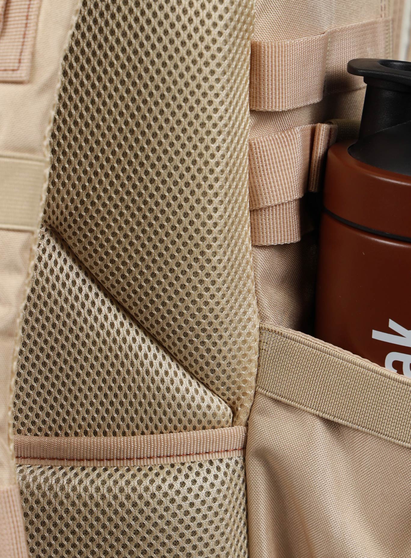 A photo focusing on the back mesh padding of the 35L Bombshell Sportswear backpack in Latte color