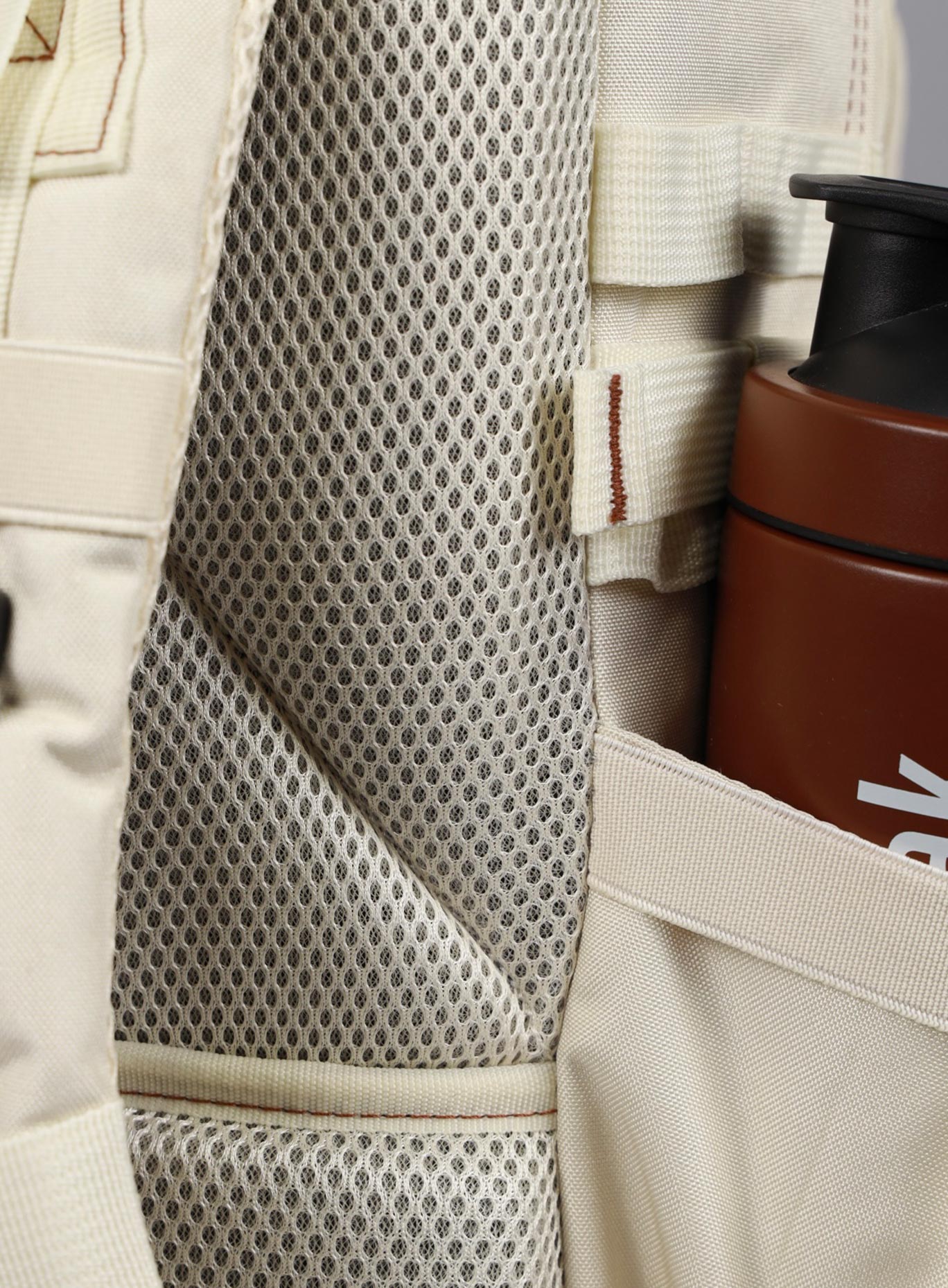 A photo focusing on the back mesh padding of the 35L Bombshell Sportswear backpack in  Crème color.