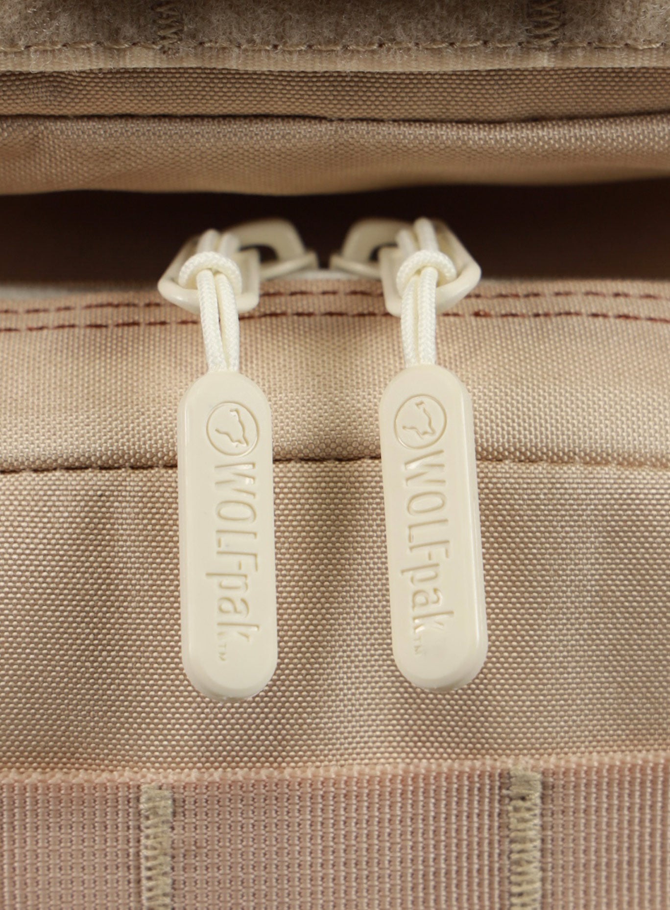 A detailed view of the zipper pull featured on the 35L Bombshell Sportswear backpack latte color