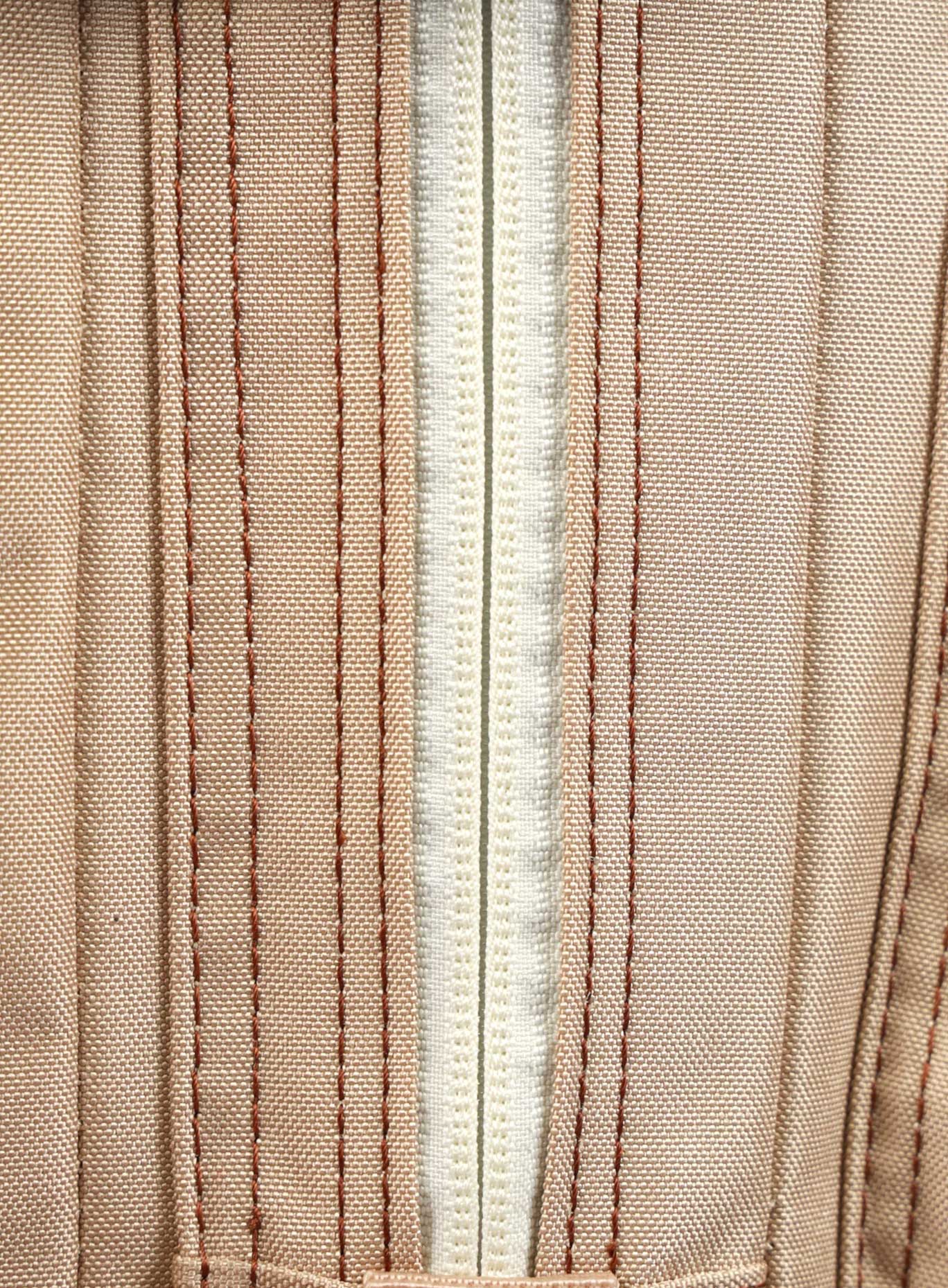 A close-up image highlighting the zipper of the 35L Bombshell Sportswear backpack in Latte color