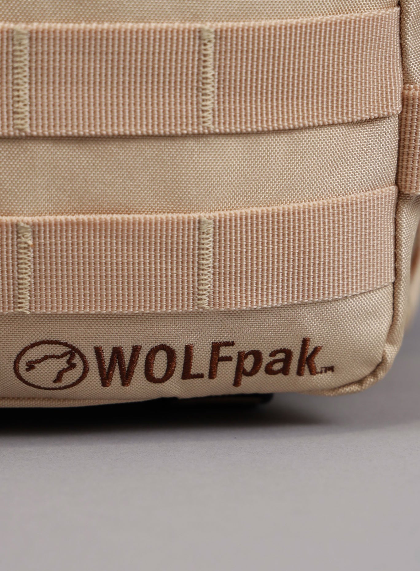 An image highlighting the WOLFpak logo on the 35L Bombshell Sportswear backpack in Latte color