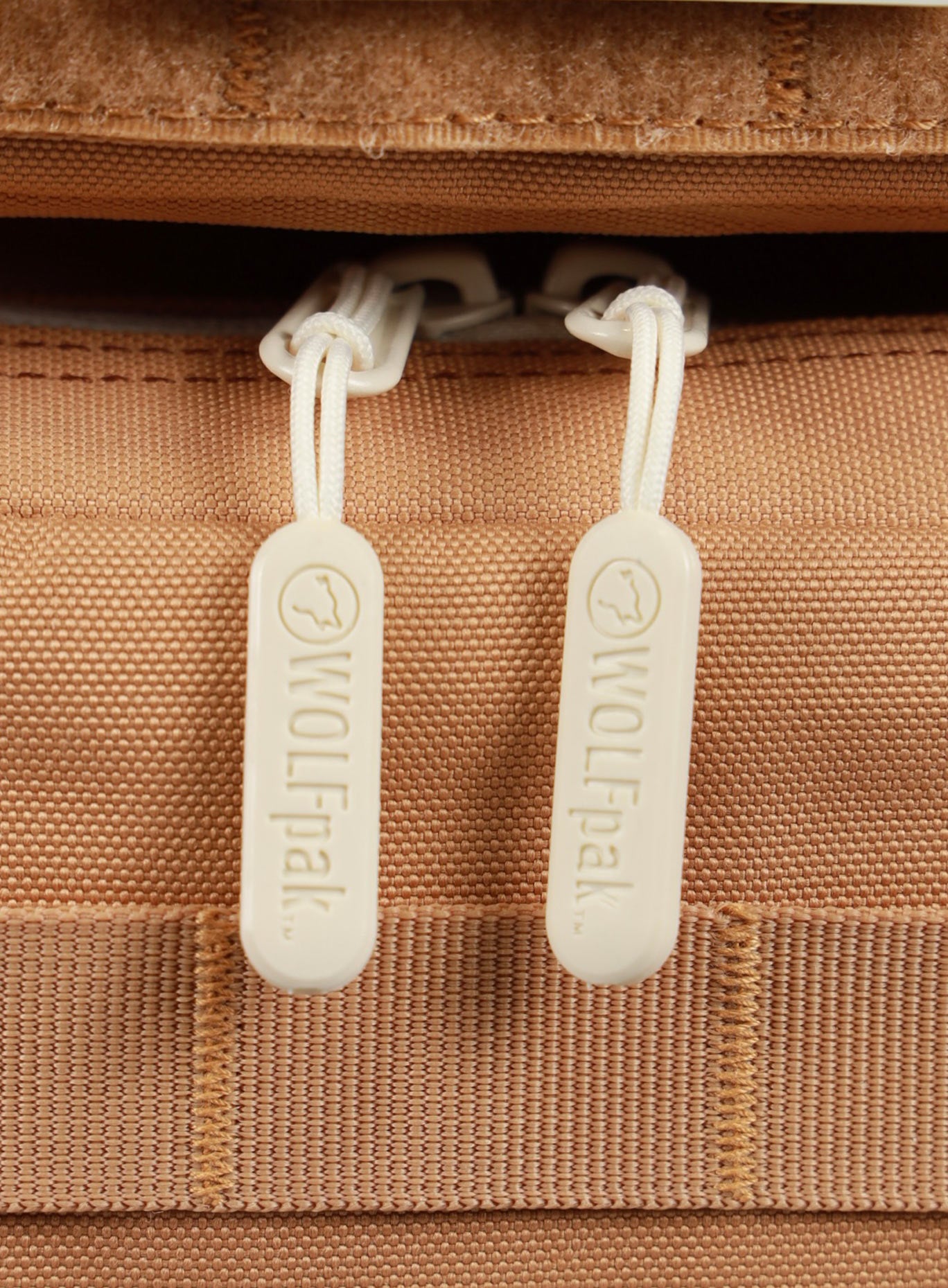 A detailed view of the zipper pull tab featured on the 35L Bombshell Sportswear backpack Caramel color