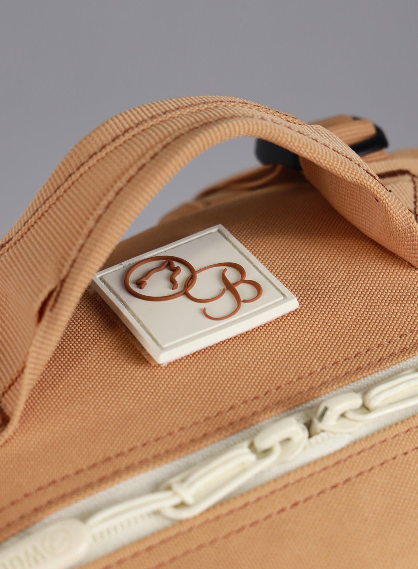 A detailed view of the zipper pull featured on the 35L Bombshell Sportswear backpack Caramel color