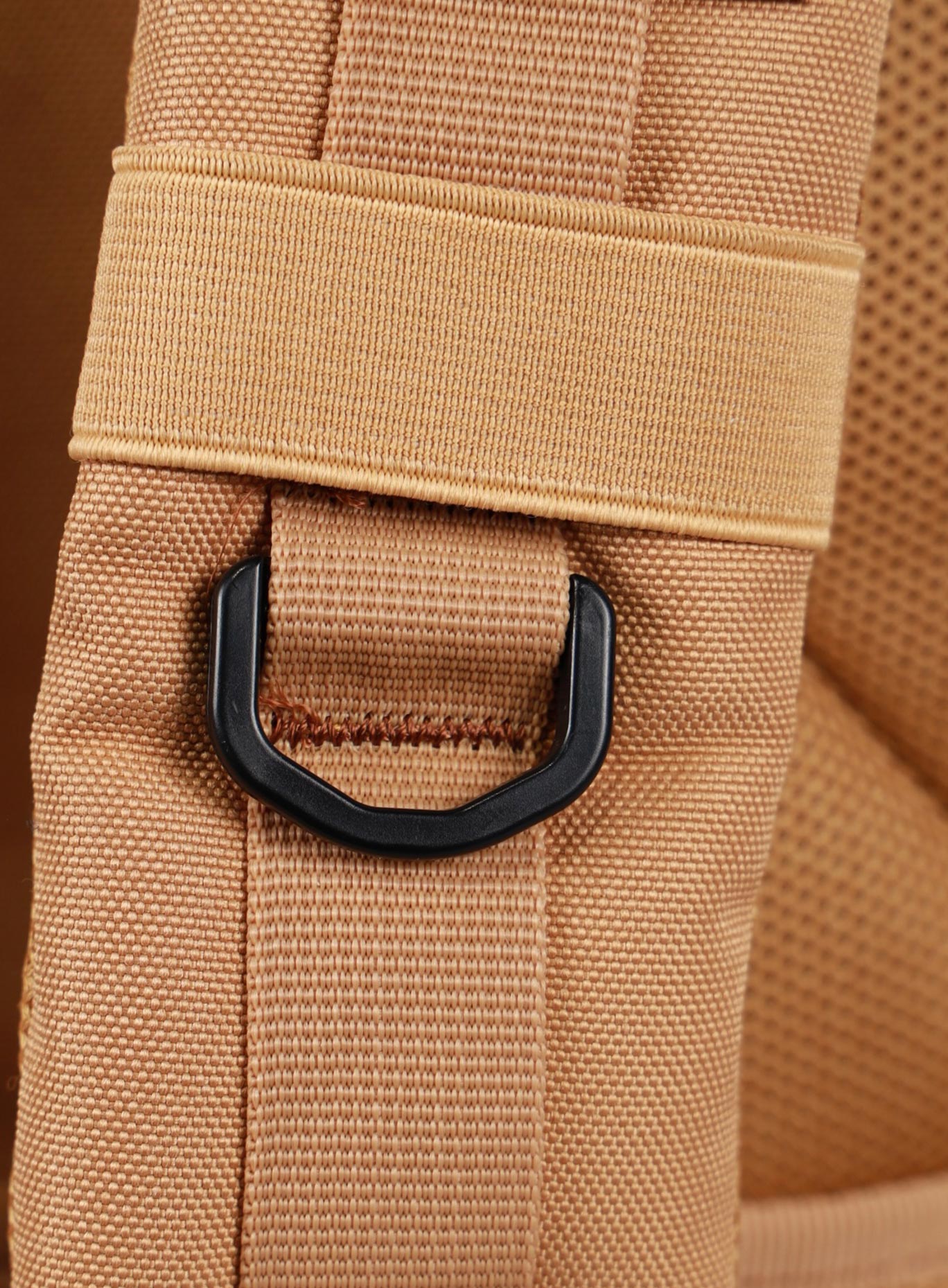 A photo focusing on the shoulder strap of the 35L Bombshell Sportswear backpack in Caramel color