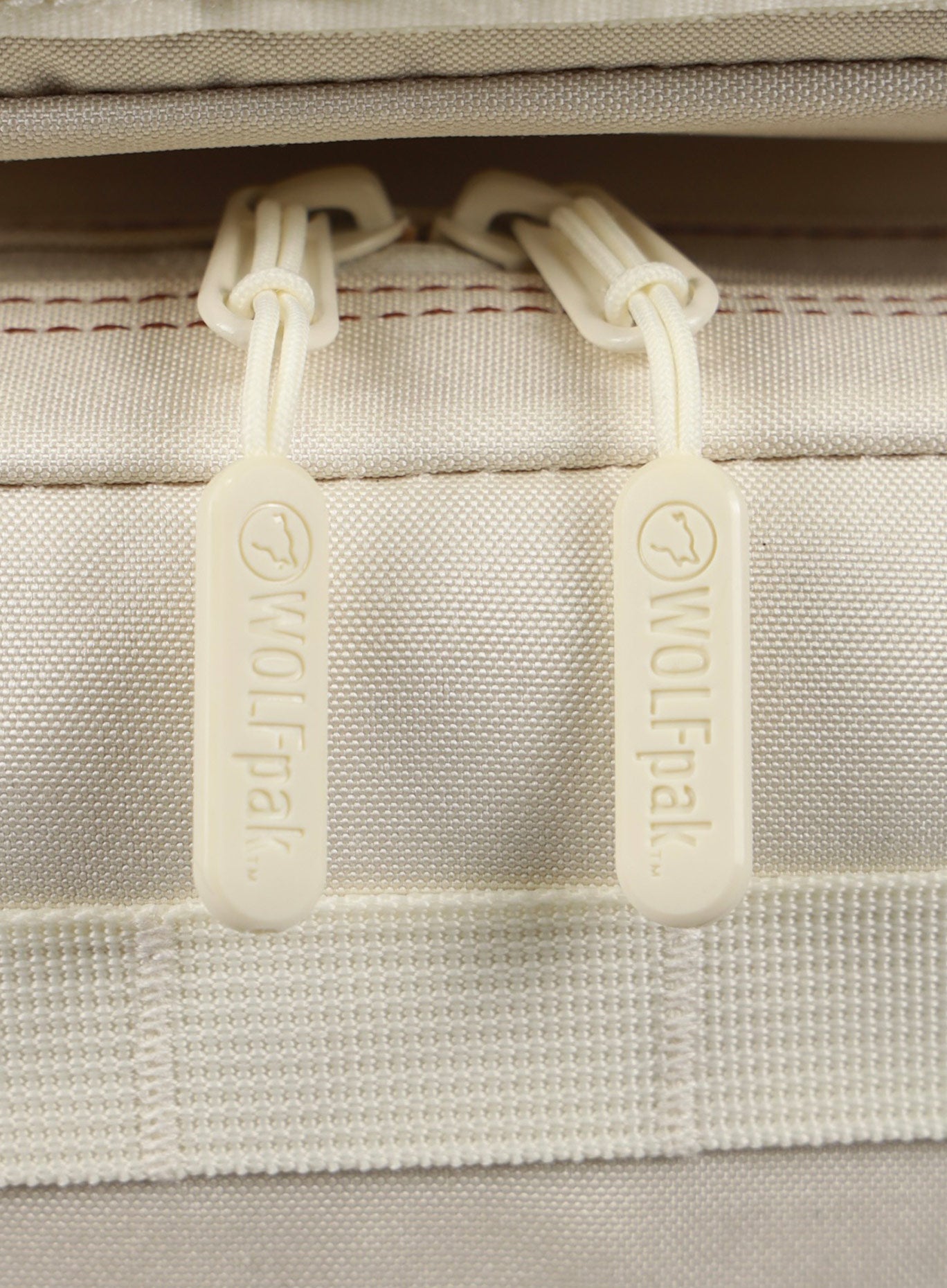 A detailed view of the zipper pull featured on the 35L Bombshell Sportswear backpack  Crème color