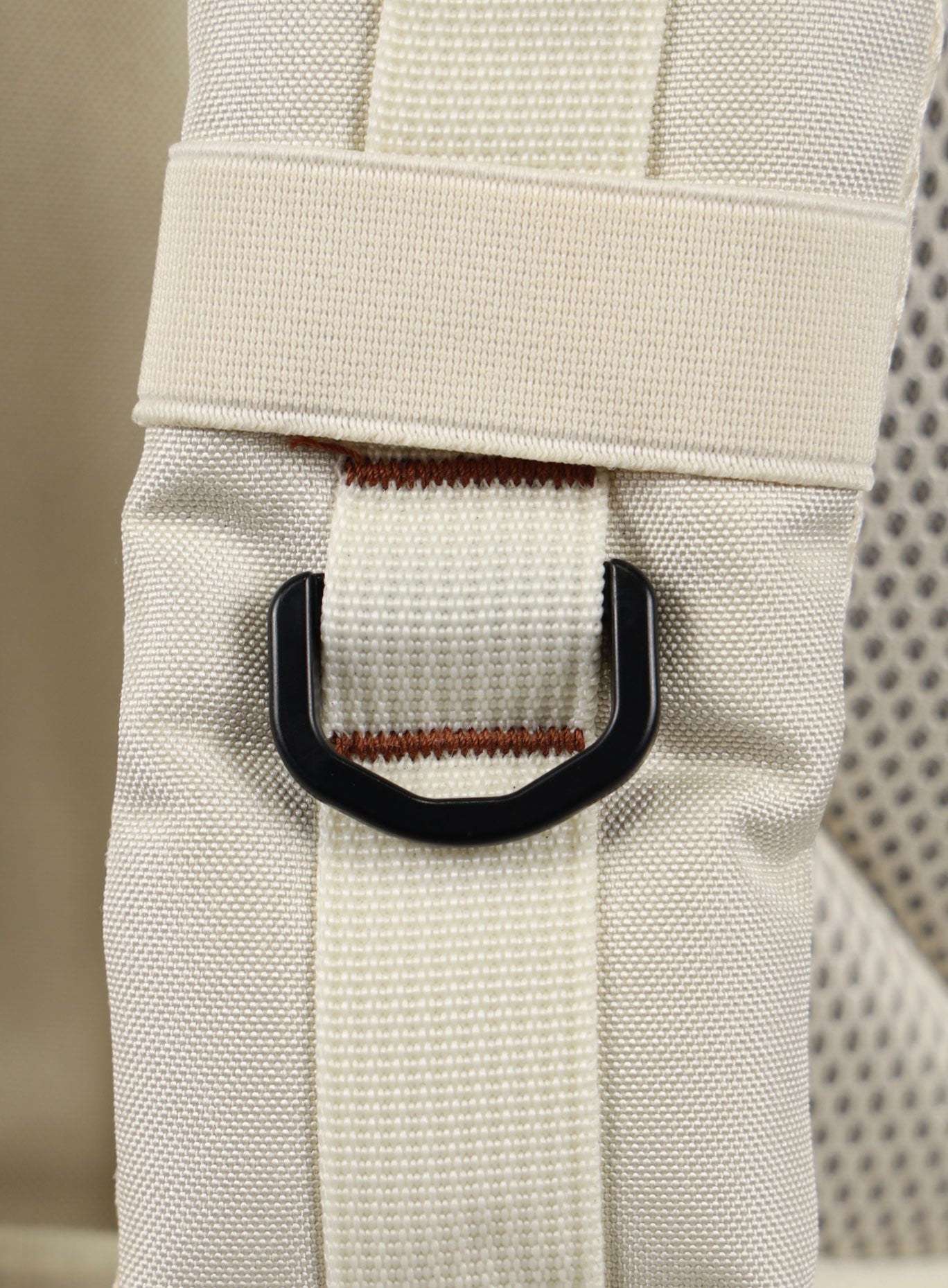 A photo focusing on the shoulder strap of the 35L Bombshell Sportswear backpack in  Crème color