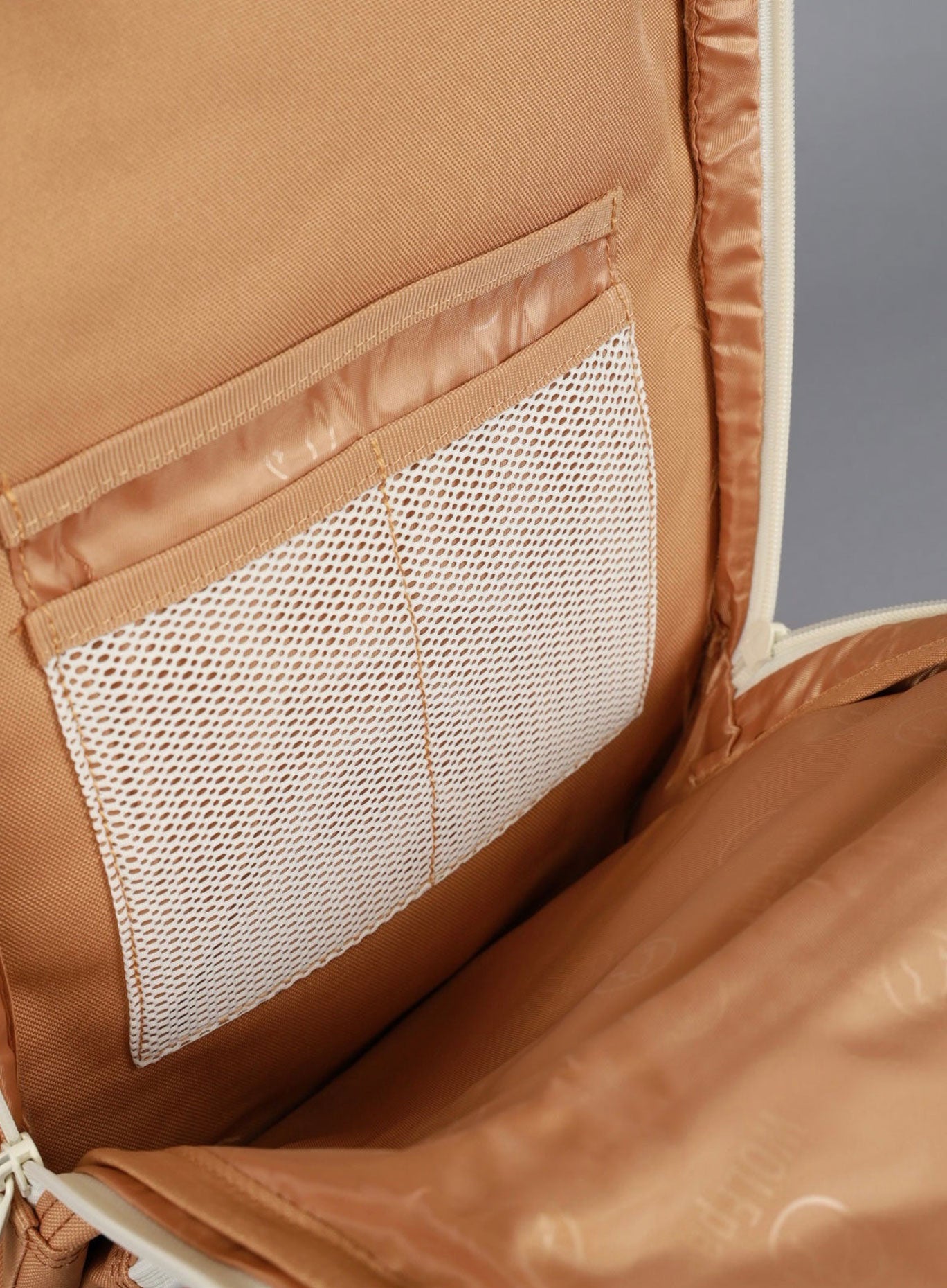 a picture of the wolfpak mini backpack inner pockets in caramel color to hold various items 