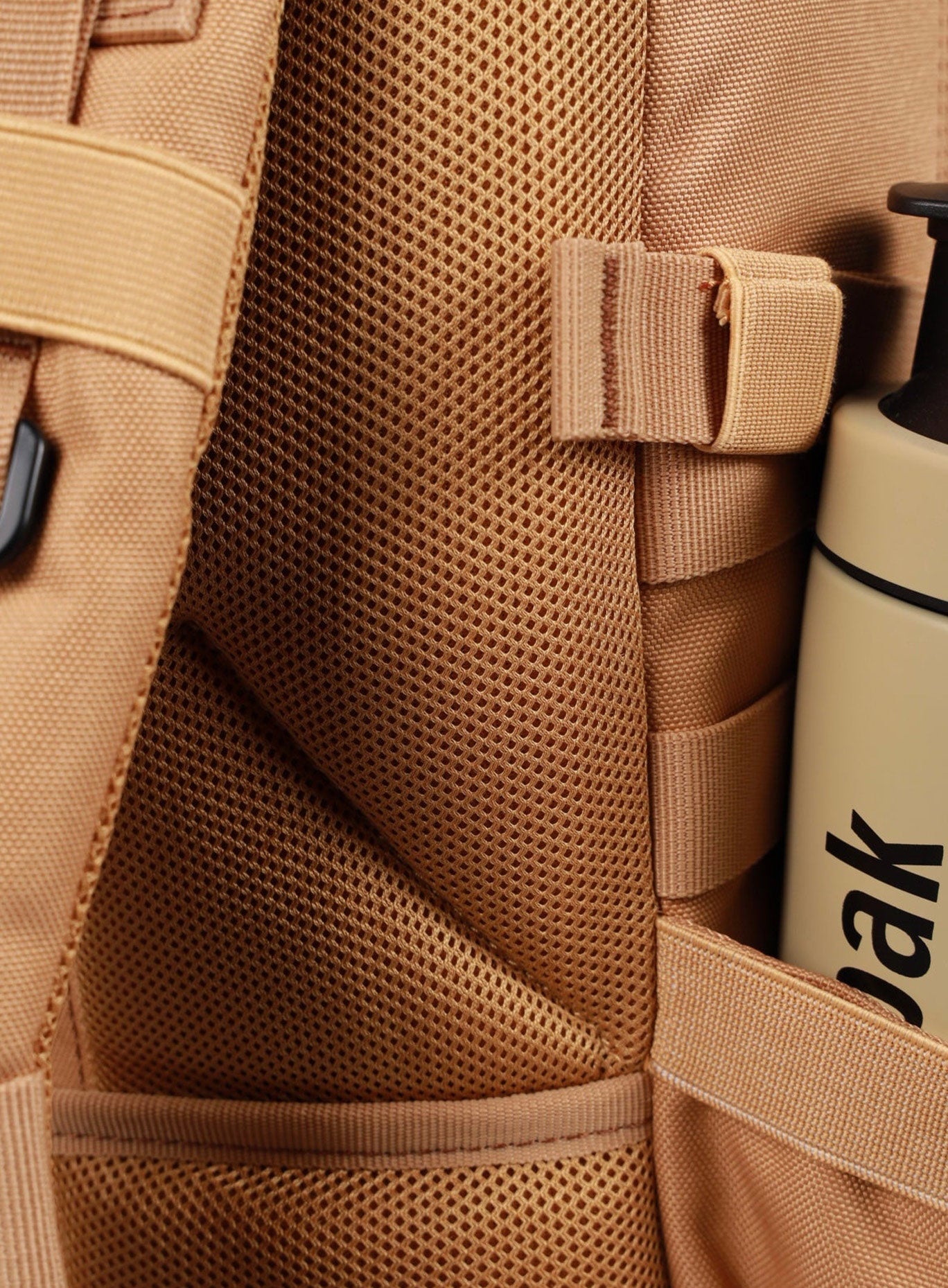 zoomed in side view of the wolfpak mini backpack in caramel 