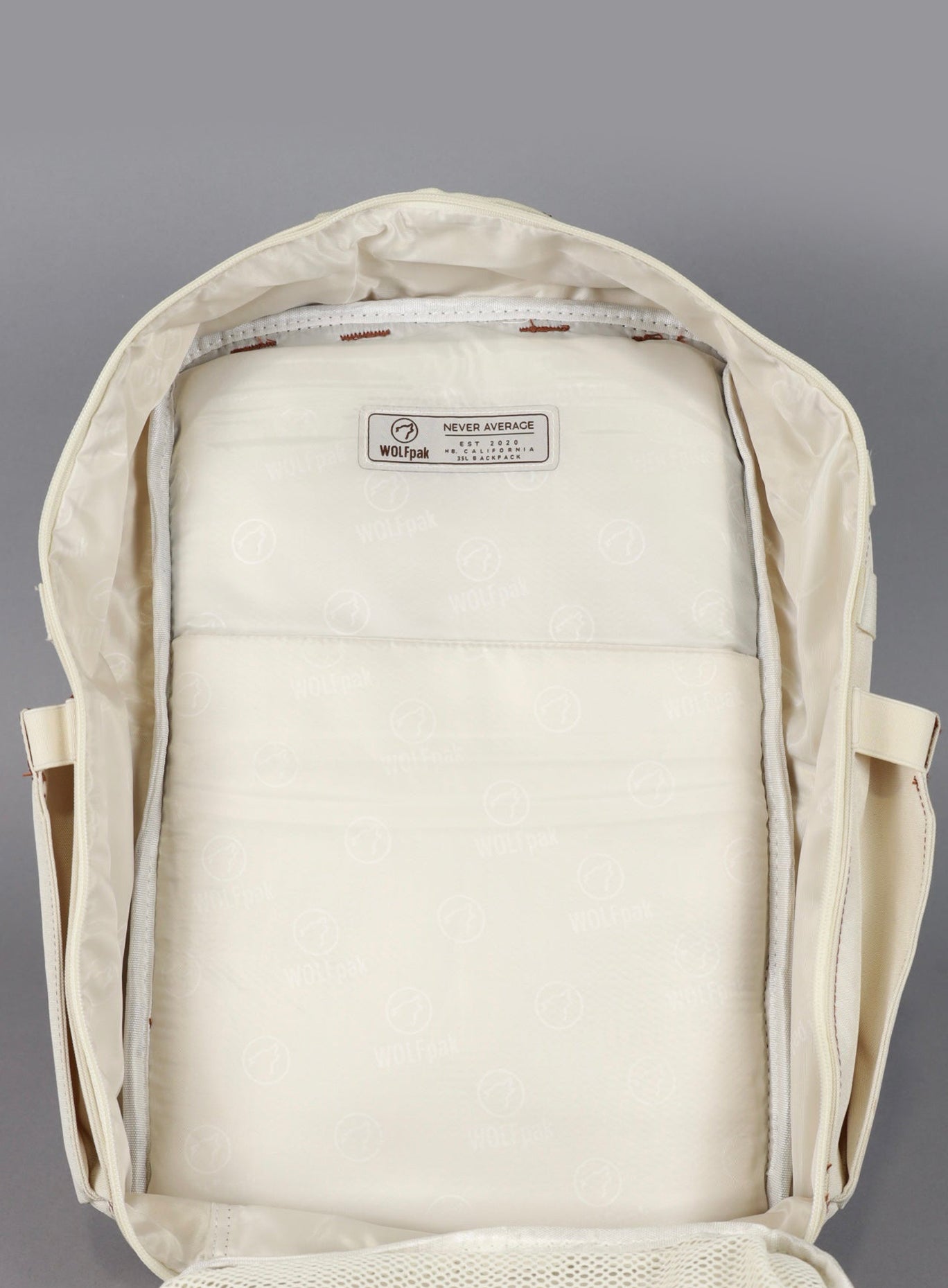 a picture of the biggest compartment showing the company badge of the Wolfpak backpack in 35L in creme color 