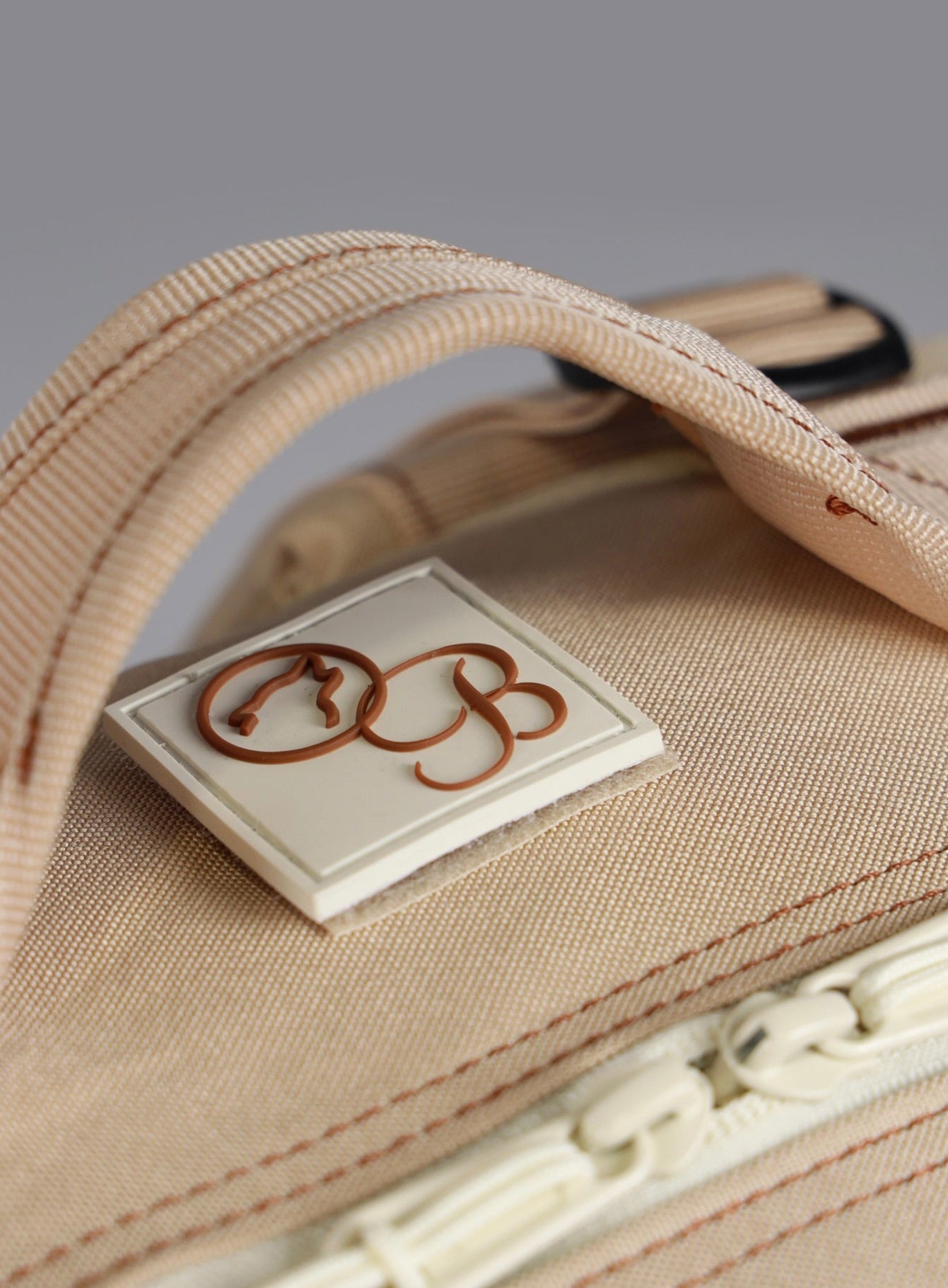 picture of the bombshell badge on the top of the wolfpak backpack in 35L in latte color 
