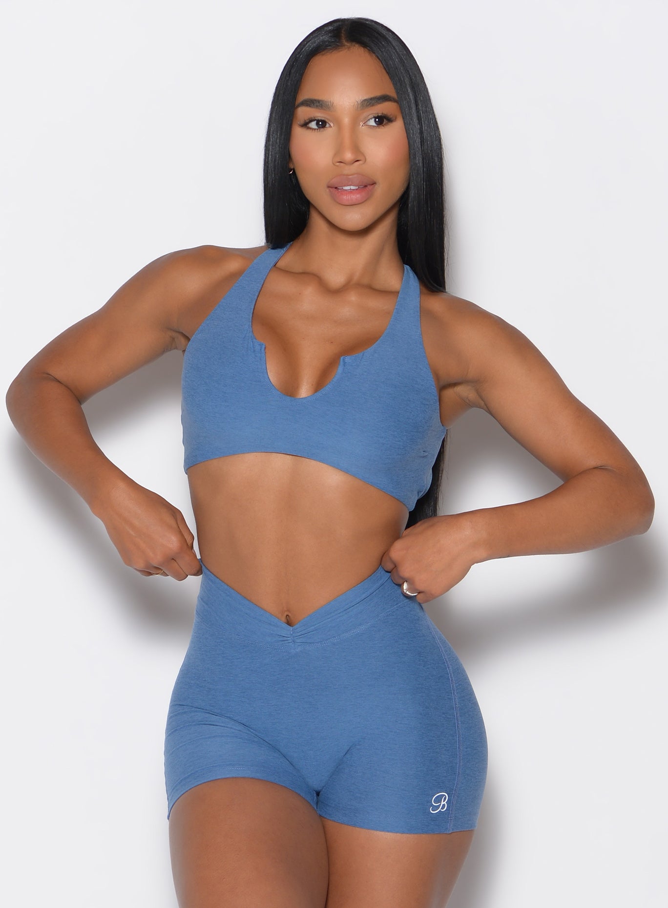 front profile view of a model wearing our Ace Sports Bra and the matching shorts in Chambray color