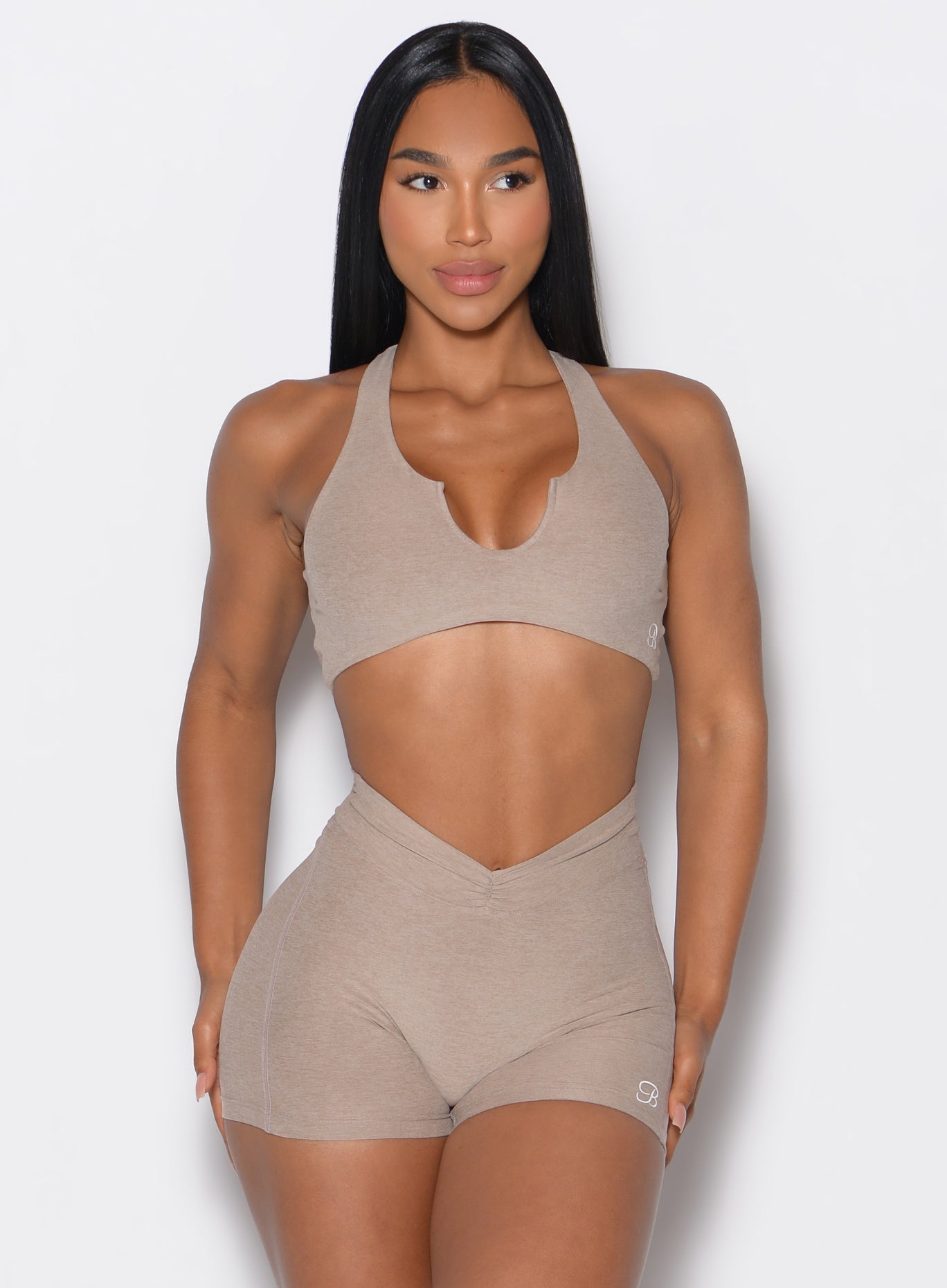 front profile view of a model wearing our Ace Sports Bra and the matching shorts in Desert Taupe color