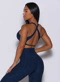 Back profile view of a model in our ace sports bra in sapphire blue color and a matching leggings