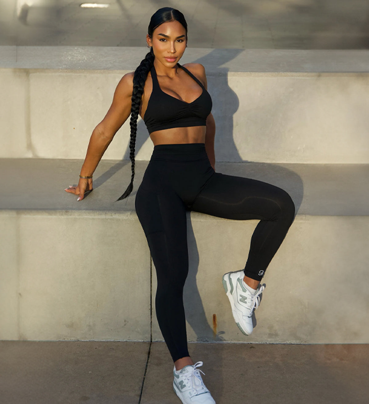 front view of model sitting down wearing black activewear set