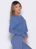 right side profile view of a model wearing the Allure Pullover in blue chill color