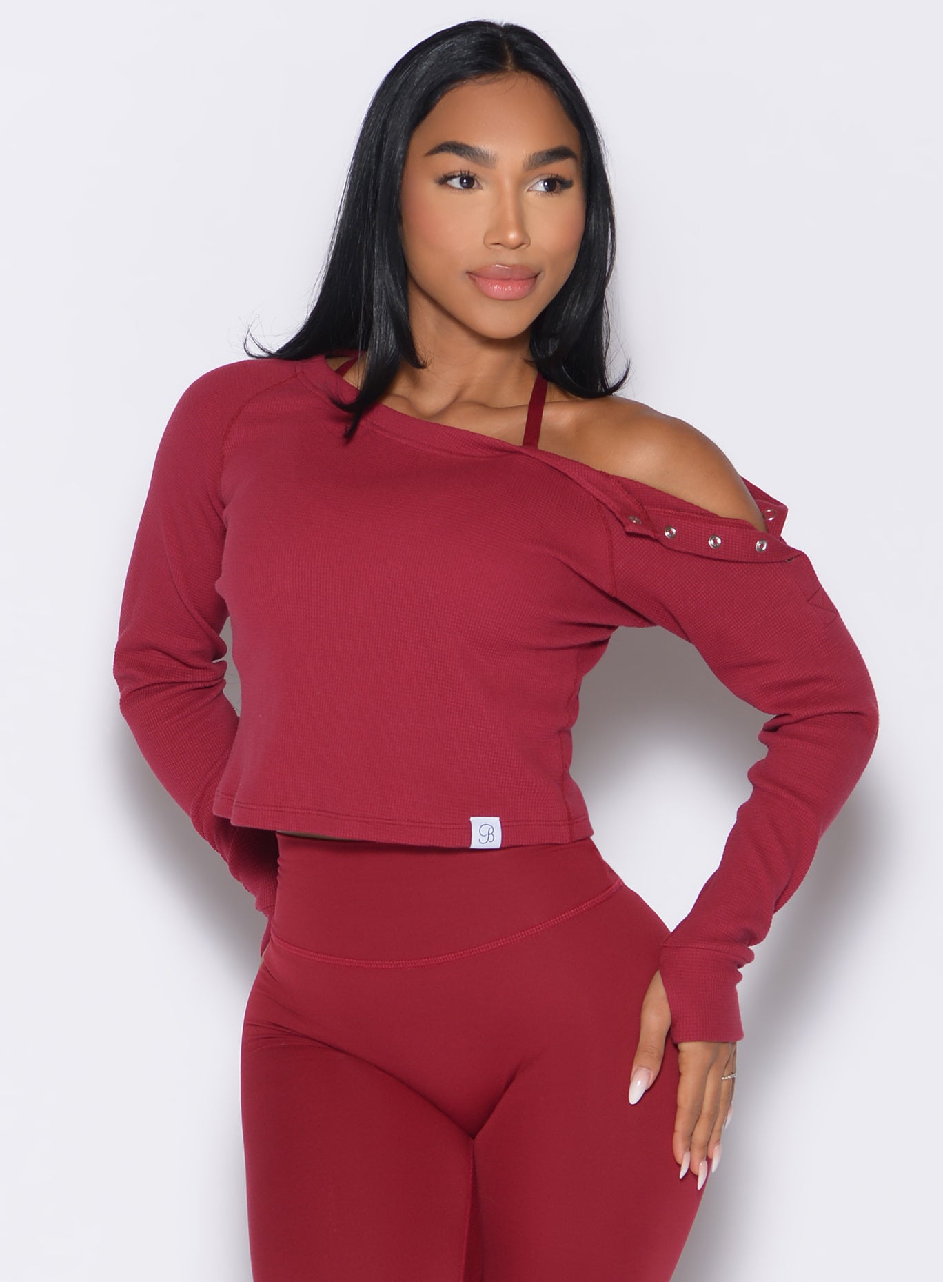 front profile view of a model looking to the left side wearing the Allure Pullover in red velvet color