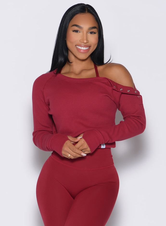 front profile view of a model holding both of her hands in front of her wearing the Allure Pullover in red velvet color