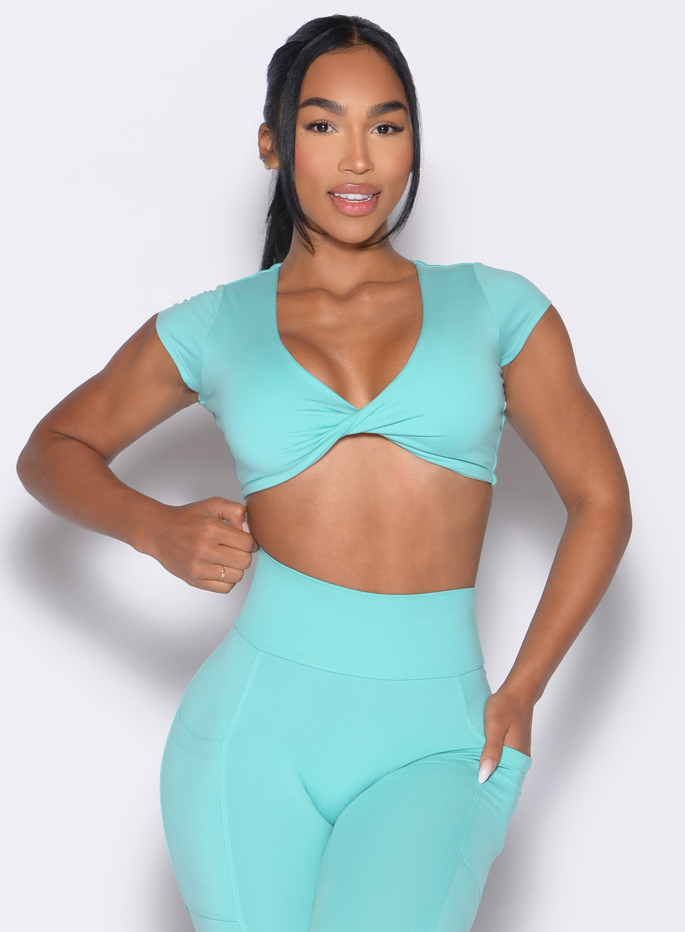 front profile view of a model wearing the Fab Bust Bra in Aquatic Awe color paired with the matching leggings