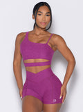 Model facing forward wearing our Asymmetrical Slit Bra and the matching Tiny Waist Shorts in Bright Plum color
