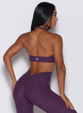 Back profile view of a model wearing our backless bra in Purple Passion color along with the matching leggings 