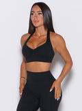 front profile shot of model in all black wearing the v back leggings and backless bra