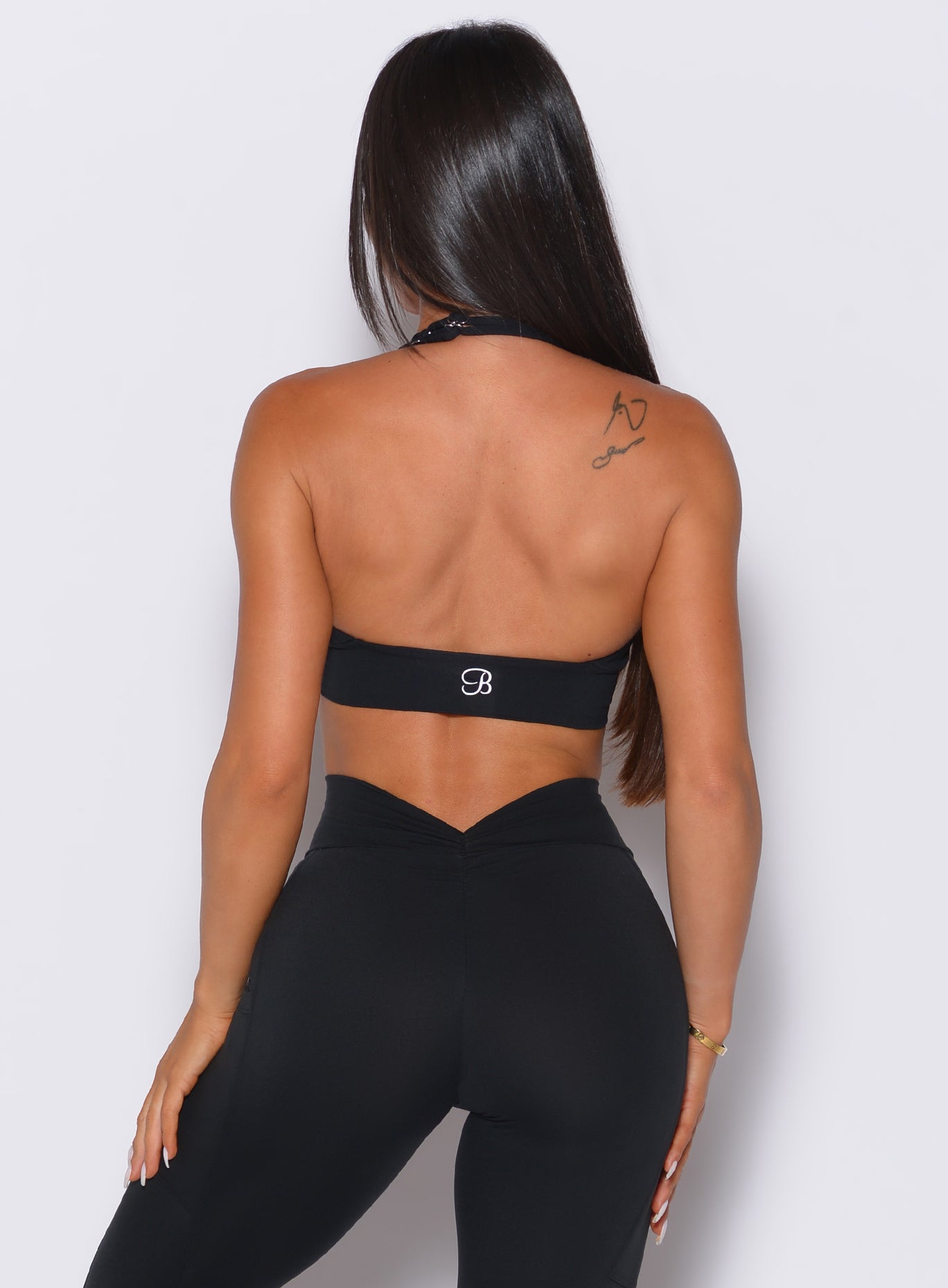 back shot of model  wearing the v back leggings and backless bra