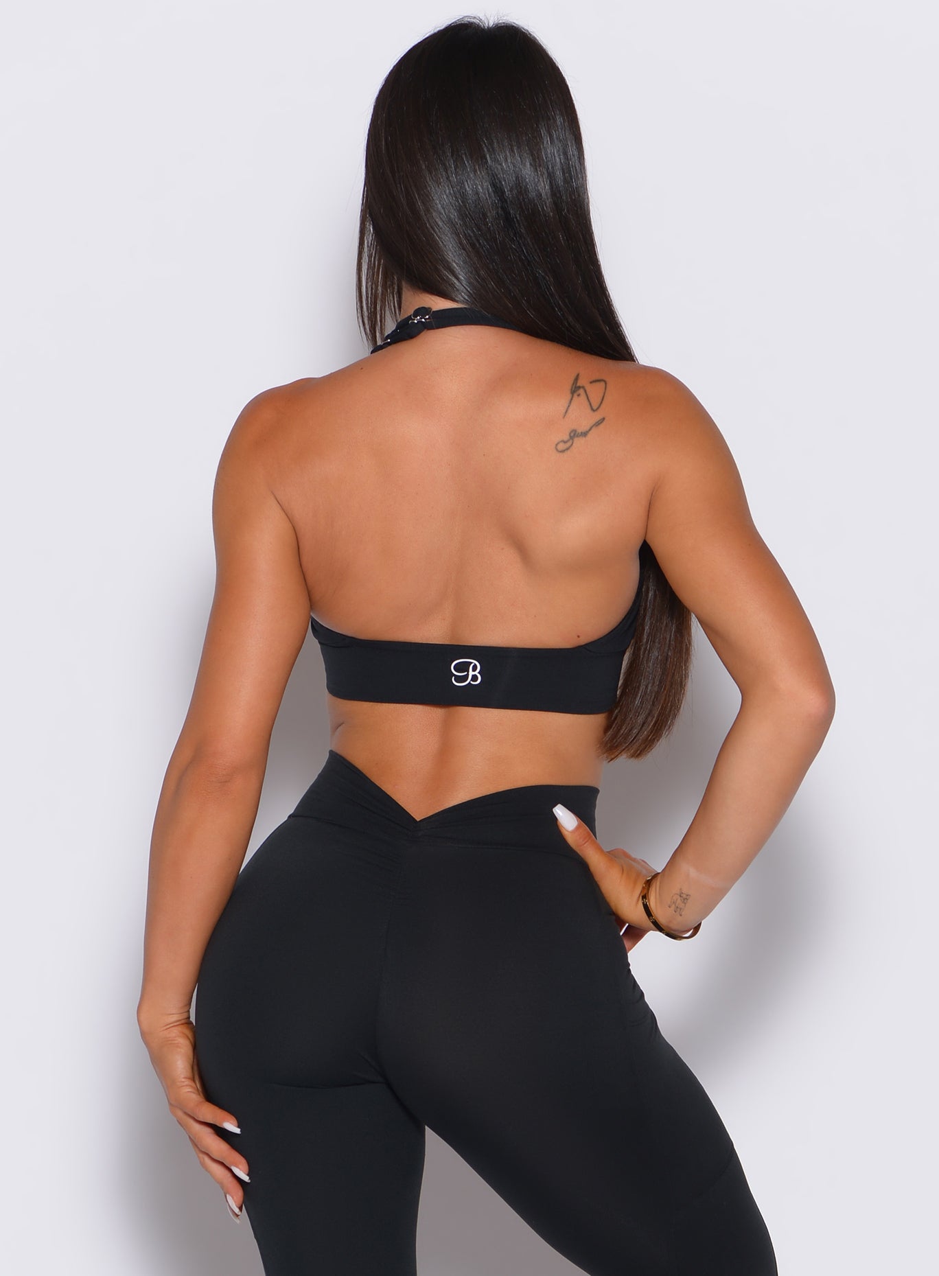 back shot of model in all black wearing  the backless bra in black