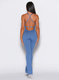 Back profile view of a model wearing the Bombshell Bunny Bodysuit in Dusty Blue