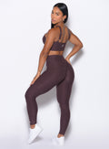 left side profile view of our model looking over her shoulder wearing the Bombshell Bunny Leggings in peppercorn color paired with the matching top