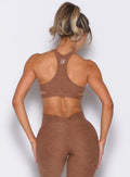 back profile view of a model wearing the Powerhouse bra in Coffee Bean color paired with the matching leggings 